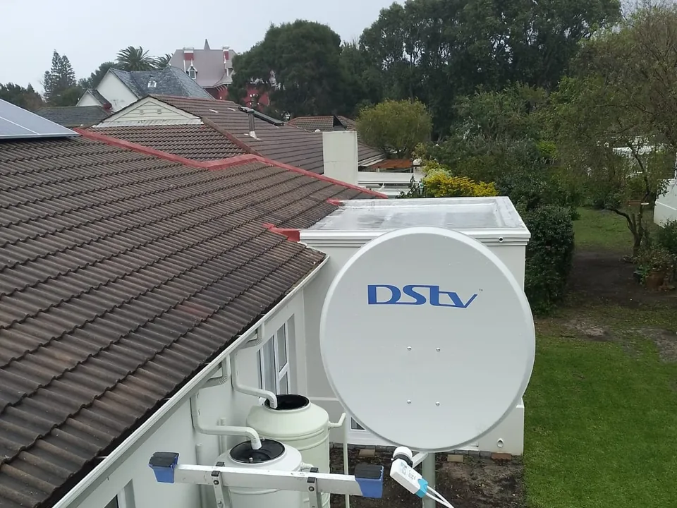 Satellite dish mounted on a roof with its bracket and cabling