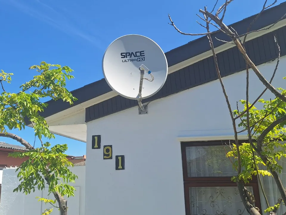 Satellite dish for a non-DStv platform mounted on a house exterior