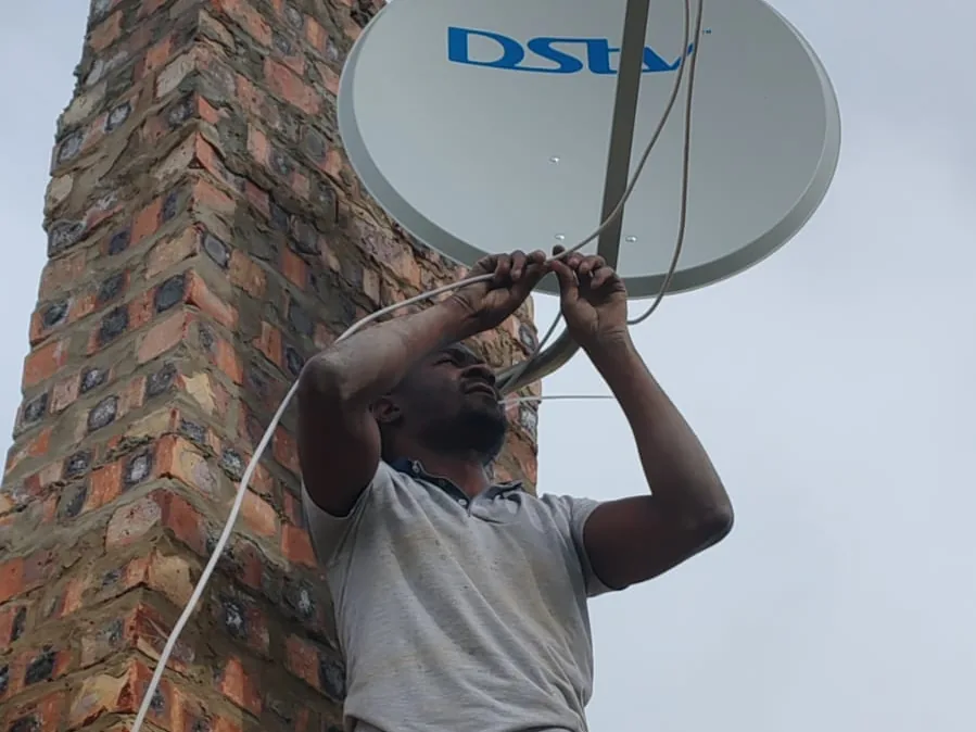Technician working at height on a satellite dish installation