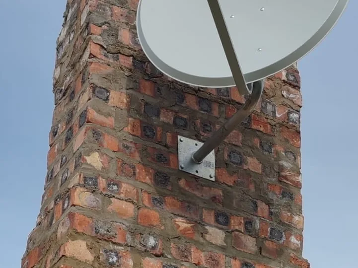 Technician working at height on a satellite dish installation