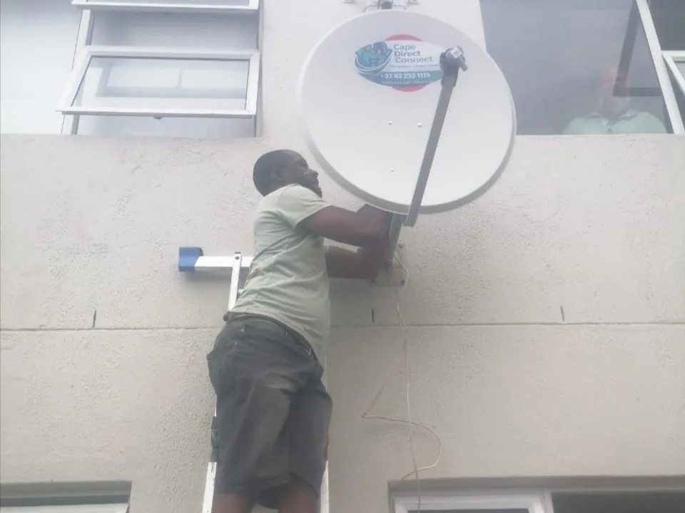 Technician working at height on a satellite dish installation