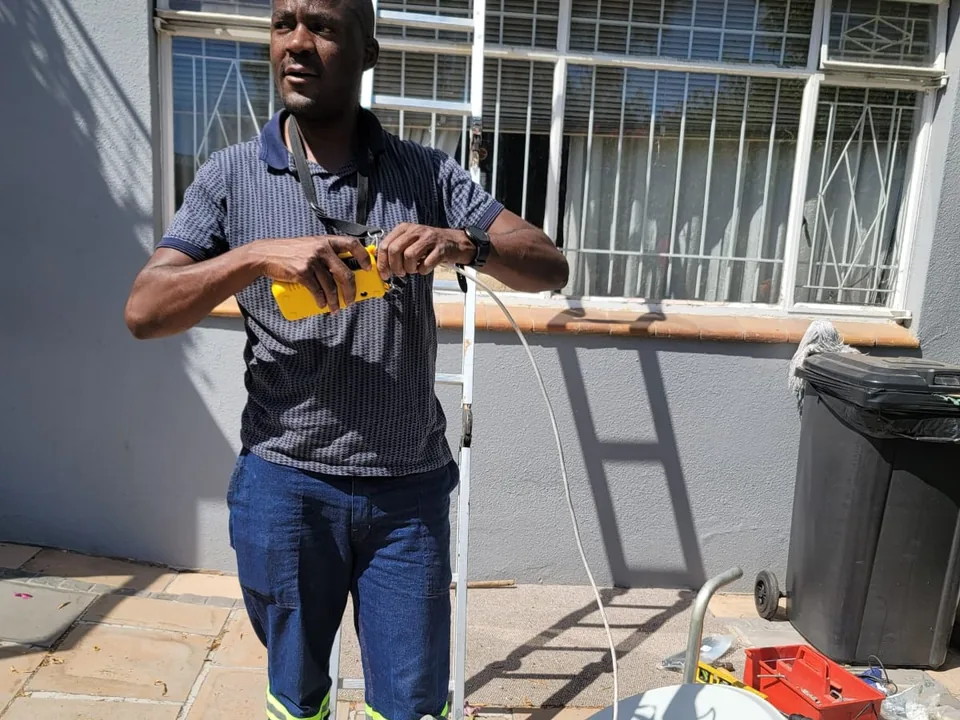 Technician holding a Cape Direct Connect branded satellite dish