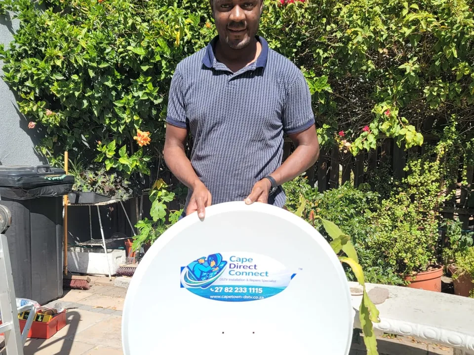 Technician holding a Cape Direct Connect branded satellite dish