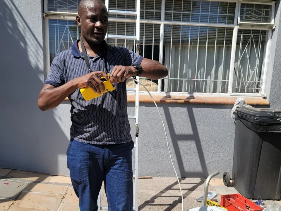Technician holding a Cape Direct Connect branded satellite dish